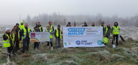 Image shows tree planters in high vis jackets holding two banners, one Watson and Marlow banner and one Veon banner